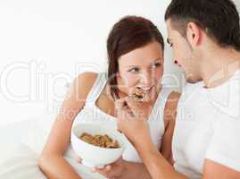 Woman fed with cereal by her man
