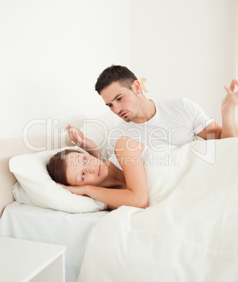 Arguing couple in a bed