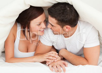 Couple hiding under a blanket