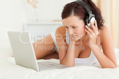 Woman listening to music working on a laptop
