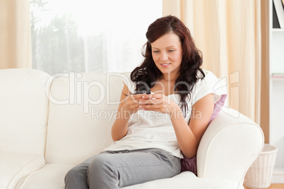 Woman sitting on a sofa while texting