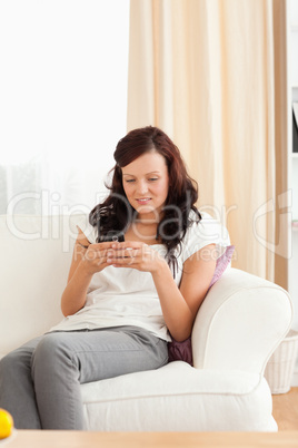 Woman sitting on a sofa texting