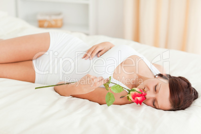 Woman with a rose having eyes closed