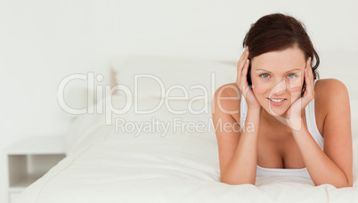 Red-haired woman lying on her bed