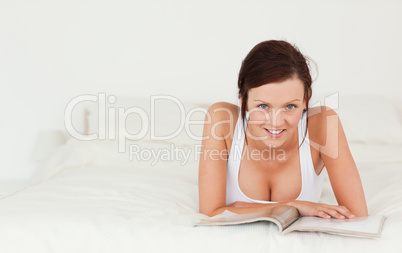 Portrait of a woman reading a magazine looking into the camera