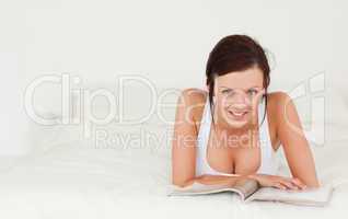 Portrait of a woman reading a magazine looking into the camera