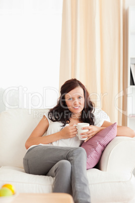 Woman holding a cup looking into the camera