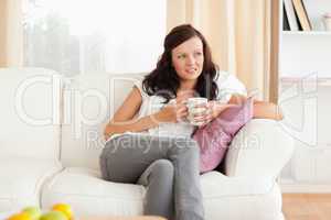 Woman holding a cup looking out the window