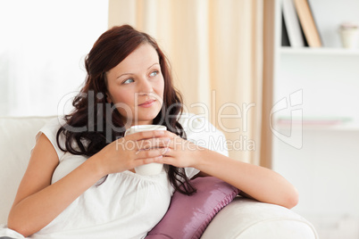 Portrait of a woman holding a cup looking out the window