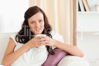Portrait of a woman holding a cup looking at the camera