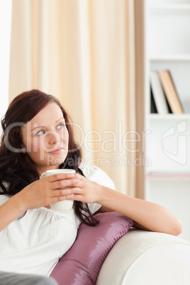 Woman holding a cup looking out of the window