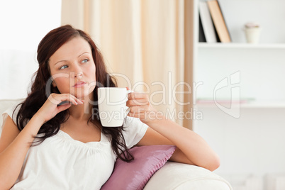 Thoughtful woman holding a cup