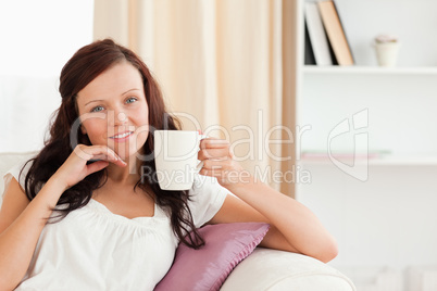 Young Woman holding a cup looking at the camera