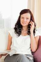 Young woman looking into camera while phoning