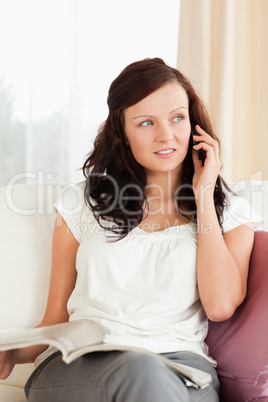 Gorgeous woman with a mobile and a magazine