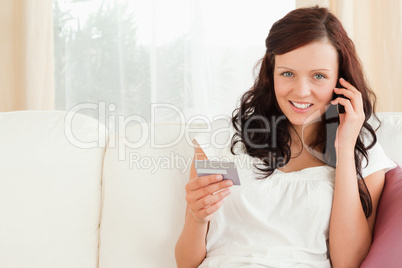 Young woman on the phone holding a card