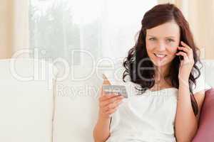 Young woman on the phone holding a card