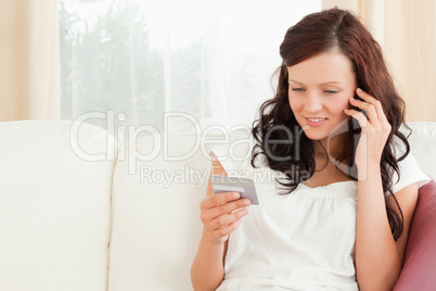 Smiling woman on the phone holding a card