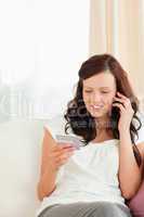 Young woman looking at her credit card holding phone