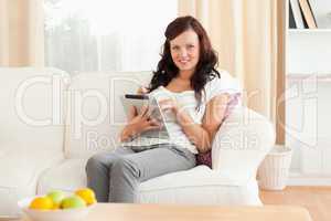 Young woman with a tablet sitting on a sofa