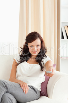 Young red-haired woman watching TV