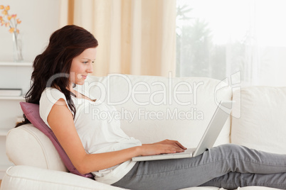 Woman with a laptop lying on a sofa