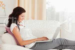 Woman with a laptop lying on a sofa