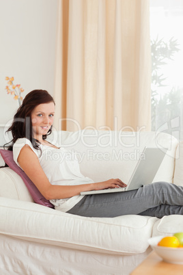 Gorgeous woman with a notebook sitting on a sofa