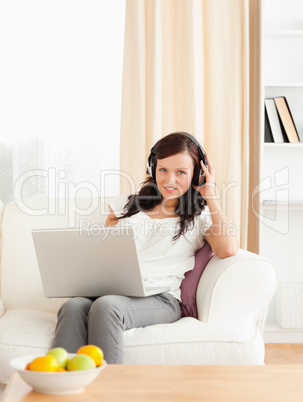 Cute woman with a notebook listening to music