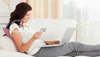 Cute woman with credit card and notebook