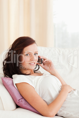 Close up of a woman sitting on a sofa with a phone