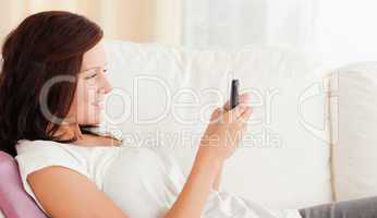 Woman texting while sitting on the sofa