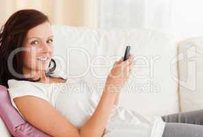 Red-haired Woman texting while sitting on the sofa