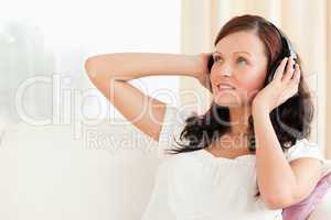 Cute woman relaxing with music on her sofa