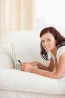 Joyful woman working on notebook with a credit card looking into
