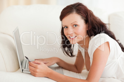 Gorgeous woman working on a laptop with a credit card