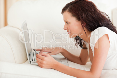 Cute woman working on a laptop with a credit card