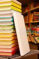 Book with white cover staying at stack of colorful books