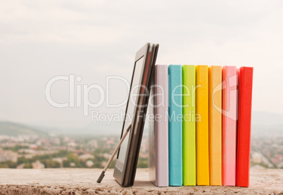 Row of colorful books with electronic book reader