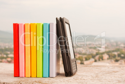 Row of colorful books with electronic book reader