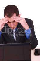 Image of businessman touching his head while looking at monitor