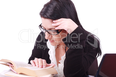 Beautiful young business woman reads the book in office .