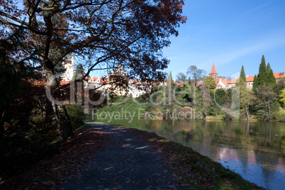 beautiful autumn landscape with colorful trees, a pond and a med