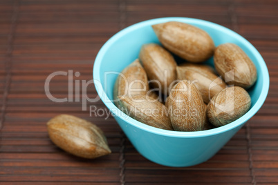 pecans in a bowl on a bamboo mat