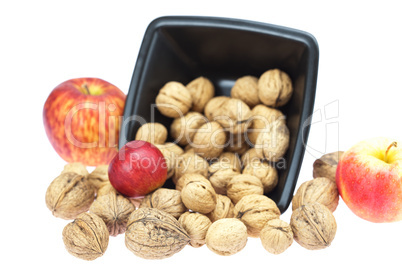 walnuts in a bowl and apples isolated on white