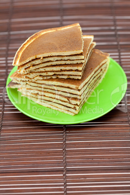 Pancakes on a plate on a bamboo mat