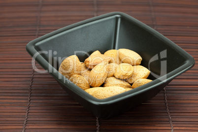 almonds in a bowl on a bamboo mat