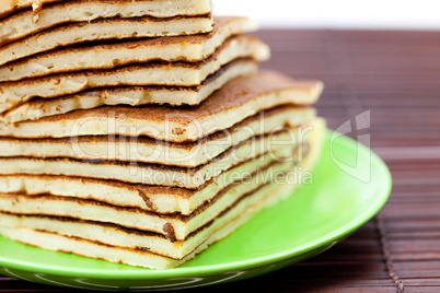 Pancakes on a plate on a bamboo mat