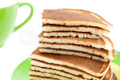 Pancakes on a plate and cup isolated on white