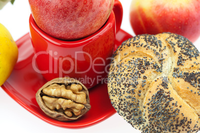 loaf with poppy seeds, quince, apples and walnuts in a cup and s